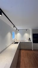 Køkkenrenovering med mørke fronter, køkkenø og brændeovn i åbent rum Køkkenrenovering med mørke fronter, køkkenø og brændeovn i åbent rum